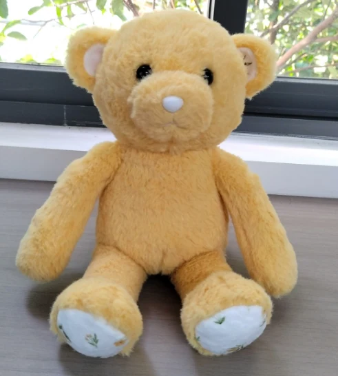 Seated teddy bear — yellow